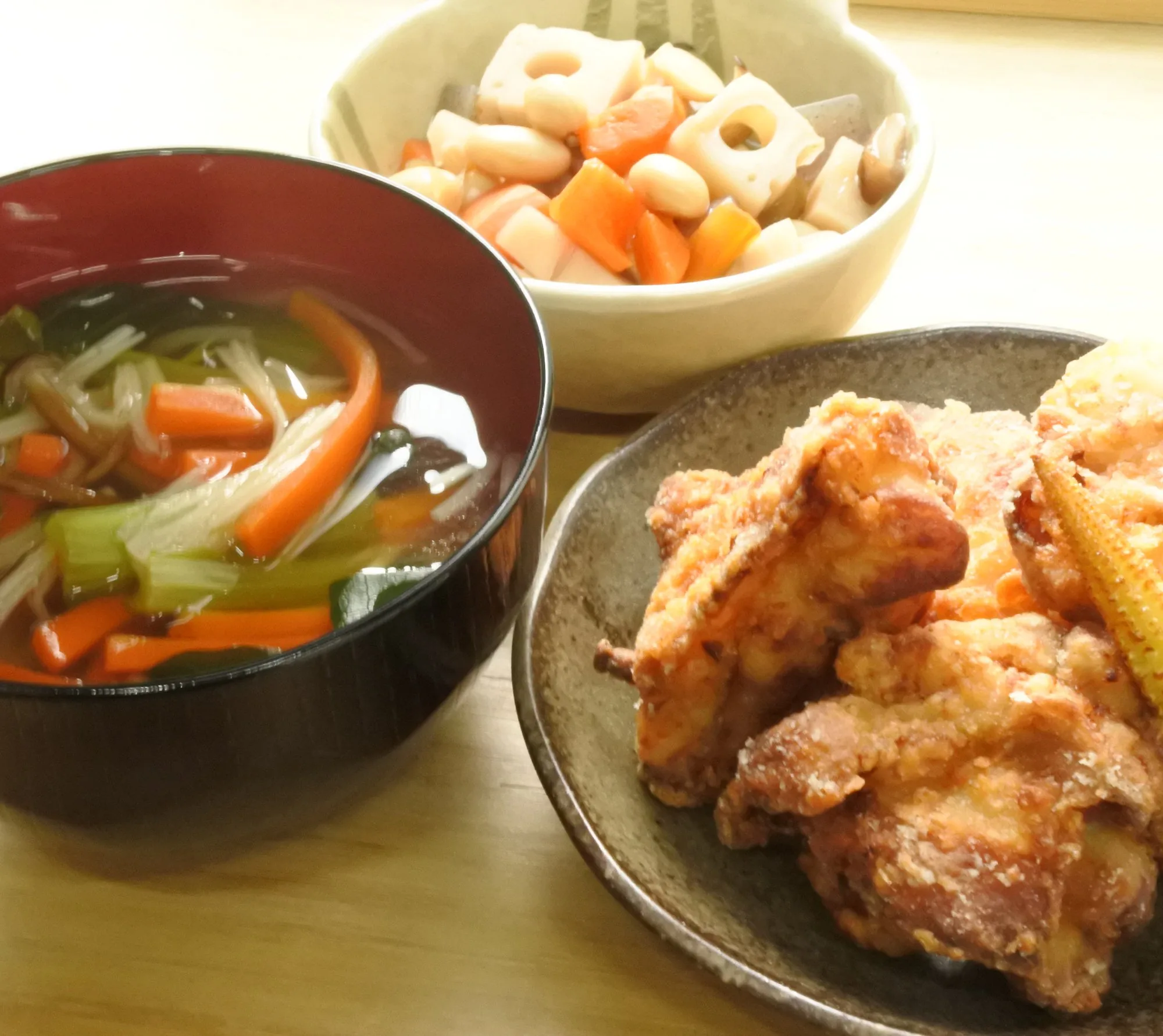 自社キッチンで作った手作りのお夕飯。塩麹からあげ・汁物・煮物が木のテーブルに並ぶ